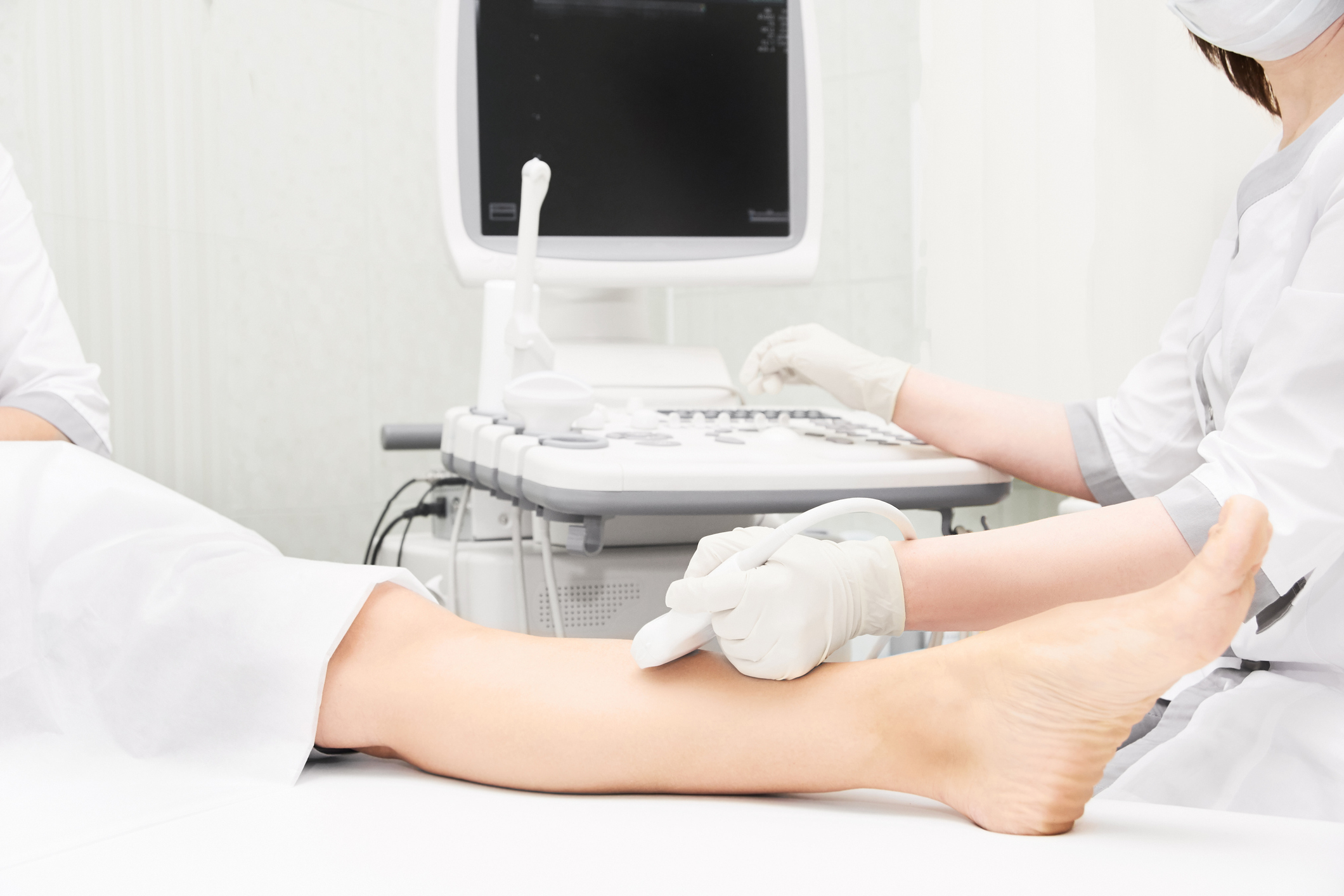 Doctor performing an ultrasound test on patient's leg