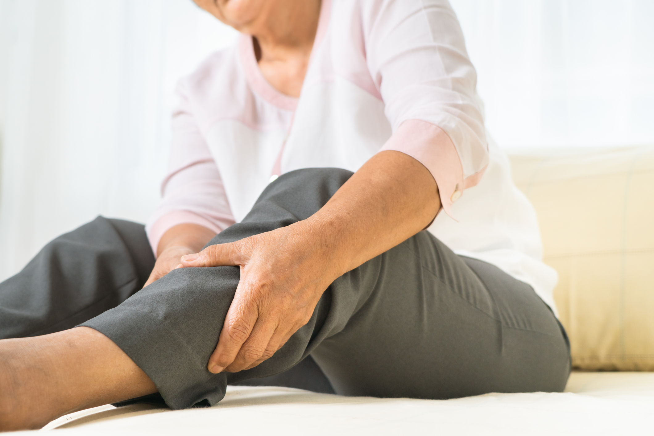 Senior woman massaging leg